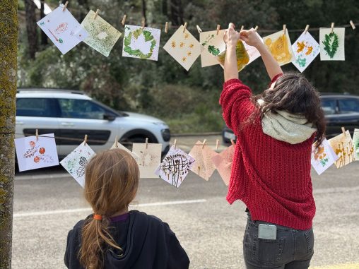 Una participant penjant una de les impressons creades per una nena